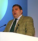 white man standing behind a microphone